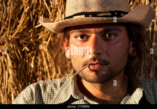 cowboy-with-straw-in-his-mouth-near-hay-